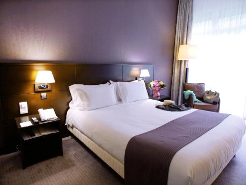 勒图凯-巴黎普拉日勒图凯假日酒店度假村的酒店客房配有一张带白色枕头的大床