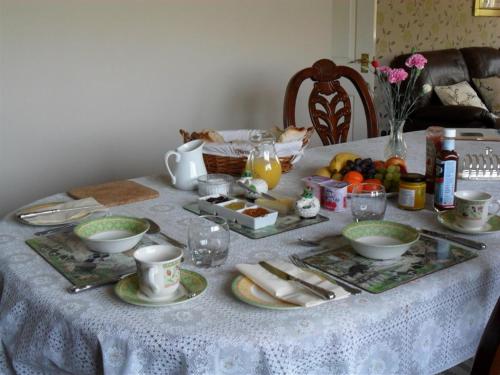 Calstock海厄查普尔农场住宿加早餐旅馆的一张桌子,上面有白色的桌布,上面有食物