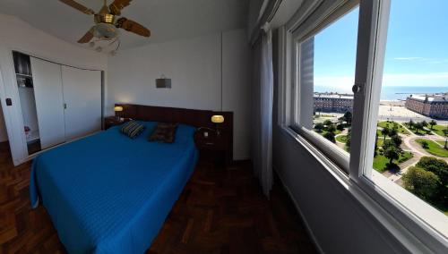 马德普拉塔EdenMDQ的一间卧室设有蓝色的床和大窗户