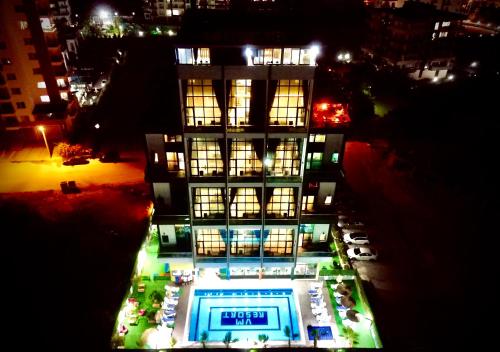 梅尔辛Vm Resort Otel Mersin的一座建筑,在晚上前方有一个游泳池