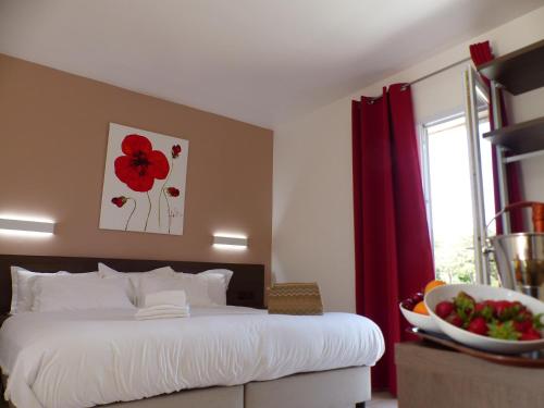马奇纳奇奥斯特拉滨海酒店的卧室配有一张挂着红色花卉画的床铺。