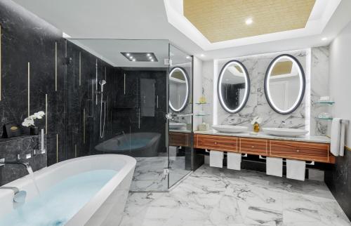 慕尼黑Mandarin Oriental, Munich - Germany's Best City Hotel 2024的浴室配有2个盥洗盆、浴缸和镜子