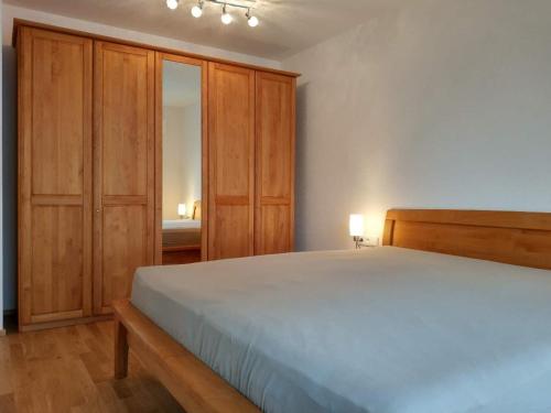 腓特烈港Apartment "SUN"的一间卧室配有一张大床和木制橱柜。
