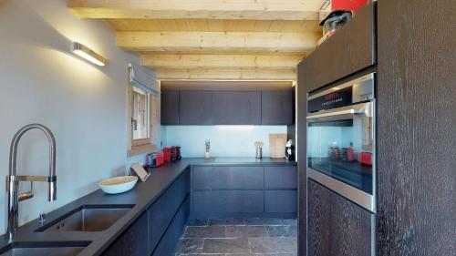 莱斯克伦斯Be Cool SAUNA & LUXURY chalet 10 pers by Alpvision Résidences的厨房配有蓝色橱柜和水槽