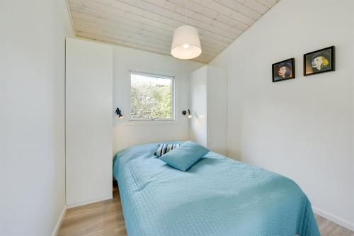 蒙克博Eksklusiv feriebolig med panoramaudsigt的一间卧室配有一张带蓝色毯子的床