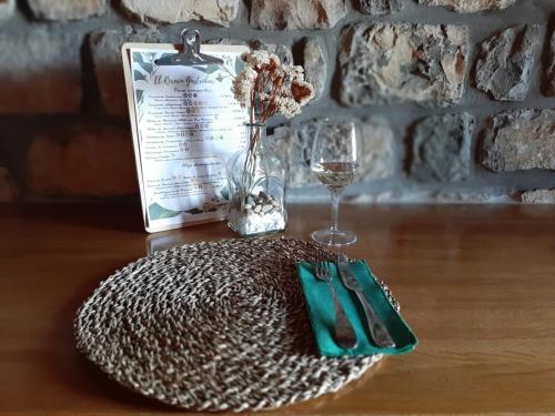 博比亚达里巴雷克萨库乡村酒店的一张桌子,上面放着盘子和一杯葡萄酒