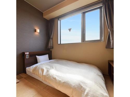 KidoHOTEL FUTABATEI - Vacation STAY 03261v的卧室配有白色的床和窗户。