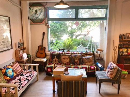 三芝乡Meo-Woo Cat Travel b&b的客厅配有家具和大窗户。