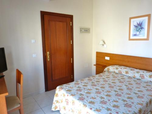 罗萨里奥港塔马塞特酒店的一间卧室配有一张床和一扇木门