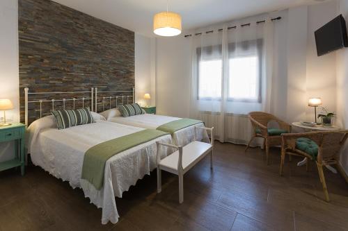 马尔帕尔蒂达德普拉森西亚恩坎托斯蒙弗拉格乡村民宿的一间卧室设有一张大床和砖墙