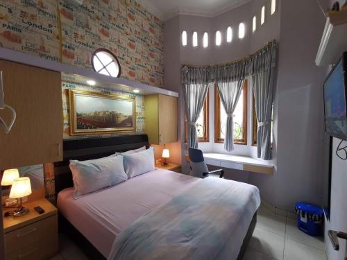 日惹纳瑞斯卡套房民宿的一间卧室设有一张大床和两个窗户。
