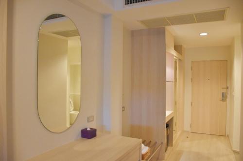 邦盛Bangsaen Heritage Hotel - SHA Plus Certified的一间带镜子和木桌的浴室