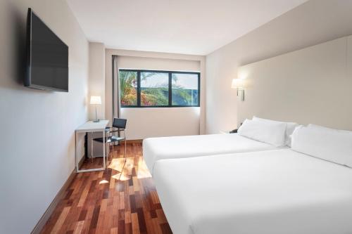 赫雷斯-德拉弗龙特拉B&B HOTEL Jerez的白色的客房配有床和电视