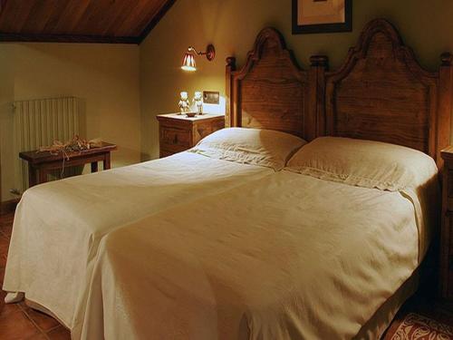 塞内圭卡斯巴斯酒店的卧室配有一张白色大床和木制床头板