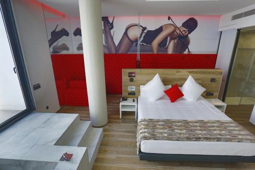 Hotel Loob Valencia的卧室配有一张床和一幅女画