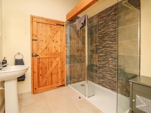 蒂弗顿Crooke Barn的带淋浴的浴室和玻璃门