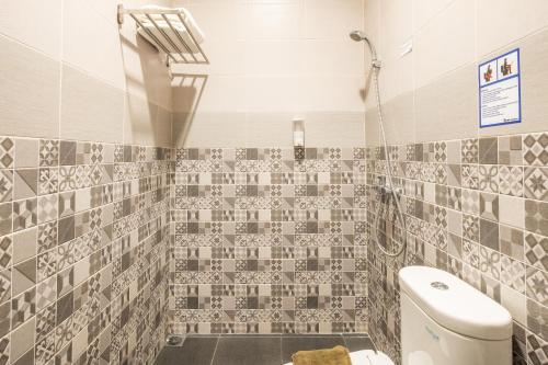 万隆Darmo Residence的一间带卫生间和瓷砖墙的浴室