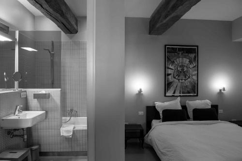 Hoegaarden厄皮库利住宿加早餐旅馆的一间卧室配有一张床,浴室设有水槽