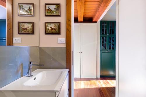 马尔泰拉戈Il Vivaio di Villa Grimani Morosini的一间带白色水槽和绿门的浴室