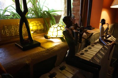 拉加罗维利亚普林西比赛罗乡村酒店的一张桌子,上面有雕像和一盏灯,旁边是窗口