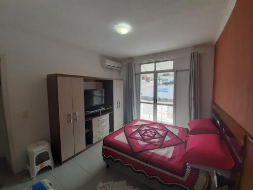 弗洛里亚诺波利斯Apto compacto em Floripa-continente的一间卧室设有一张床、一台电视和一个窗口。