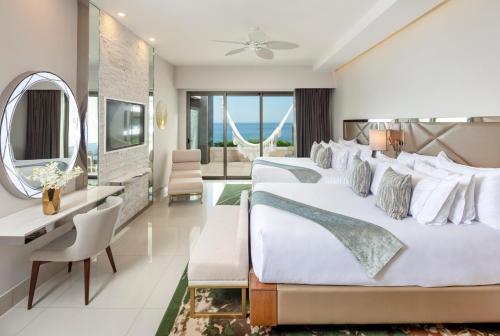 卡波圣卢卡斯Garza Blanca Resort & Spa Los Cabos的酒店客房,设有三张床和镜子