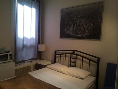 多伦多科普尼尔旅馆的卧室配有一张床,墙上挂着一幅画