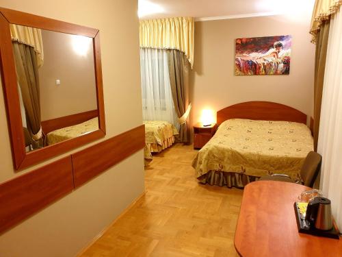 ZalasowaPałac pod Dębami的酒店客房,配有床和镜子