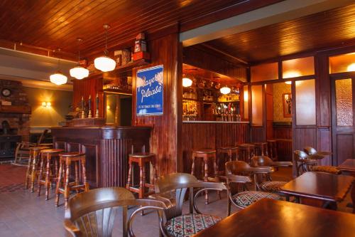 Kinnitty联排别墅的餐厅内带木椅和桌子的酒吧