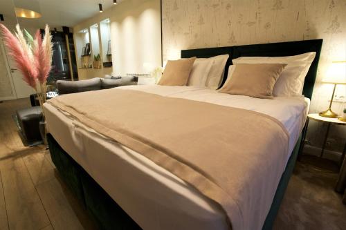 奥西耶克Apartman My Story的卧室内的一张带白色床单和枕头的大床