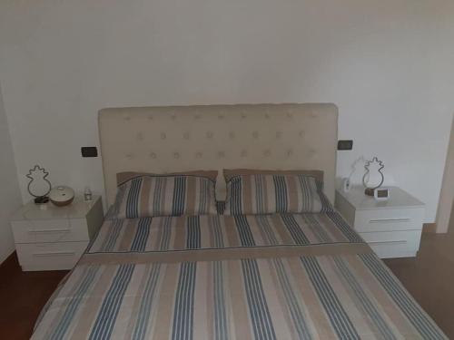 代森扎诺-德尔加达APPARTAMENTO LAKE GARDA ibiscus di Francia的一间卧室配有一张带2个床头柜的大床