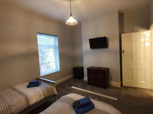 达灵顿The Shed的客房设有两张床、一台电视和一扇窗户。