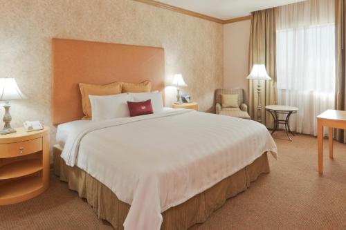 托雷翁托雷翁皇冠假日酒店的酒店客房带一张大床和一把椅子