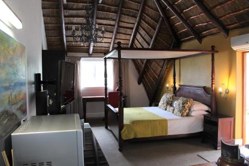 普利登堡湾Windfall Plett的一间卧室,卧室内配有一张天蓬床