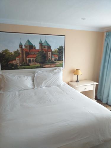 乔治阿尔卑旅馆的一张白色的床,上面有城堡的照片