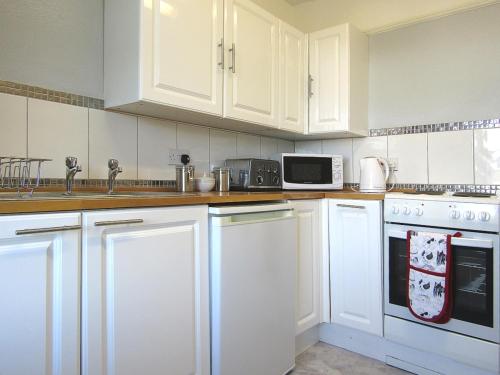 FremingtonWickham House Apartment的厨房配有白色橱柜和白色家电