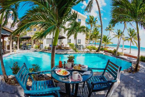 圣佩德罗鹈鹕礁别墅度假村的一张桌子,旁边是游泳池,上面有盘子的食物
