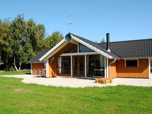 Sønder Nissum8 person holiday home in Ulfborg的房屋设有大窗户和庭院