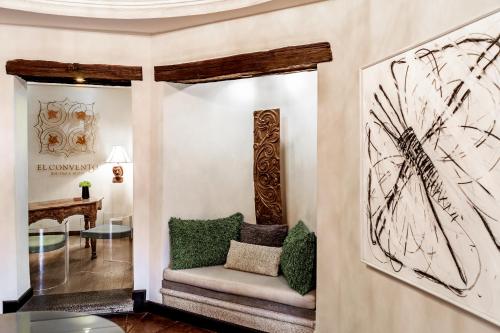 危地马拉安地瓜埃尔孔本托精品酒店的客厅配有椅子和墙上的绘画