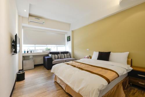 高雄237旅店的一间卧室配有一张大床和一张沙发