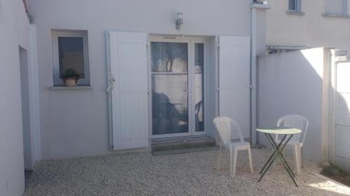 拉罗谢尔33 Ter Bon pied à terre的门前有两把椅子和一张桌子