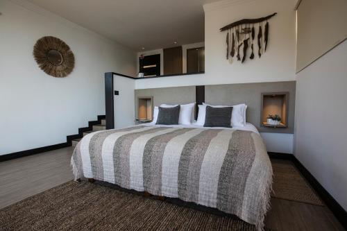 康塞普西翁Pura Lodge的一间卧室配有一张大床和镜子