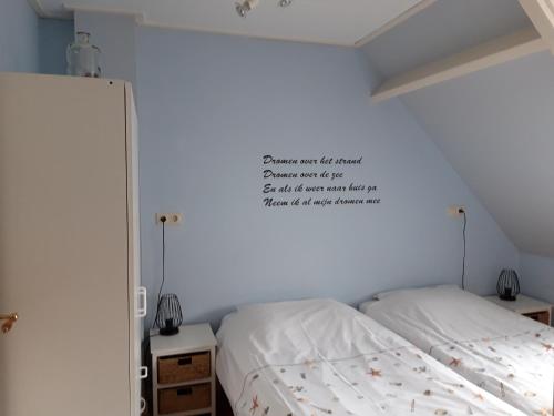 韦斯特卡佩勒Vakantiewoning 100m van het strand met 1 Slaapkamer的卧室配有一张床,墙上有标志