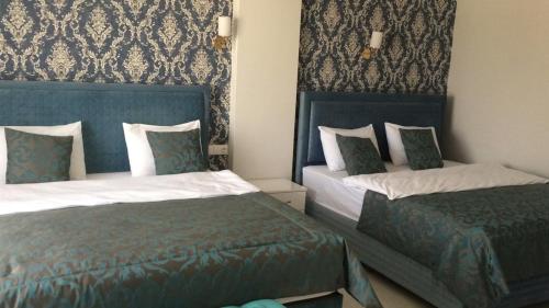 帕莫卡莱The Cotton House Hotel的一间卧室配有两张蓝色和白色的床