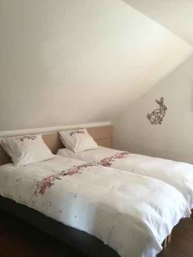 雷杜Plumes et Pinceaux的卧室配有带鲜花的白色床