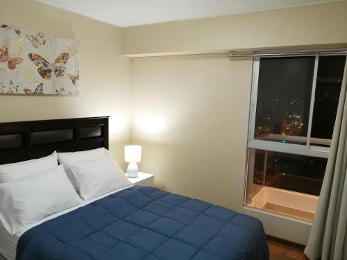 利马Departamento BH South的一间卧室设有蓝色的床和窗户。
