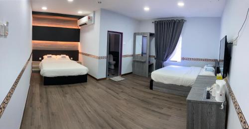 JertihTAMU KoGURU的酒店客房配有两张床和一张书桌