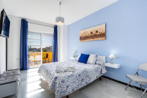 林孔-德拉维多利亚Milestone House的一间卧室配有一张蓝色墙壁的床和一扇窗户