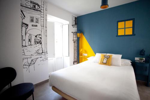 塞维利亚Lukanda Hospec的卧室配有白色的床和蓝色的墙壁