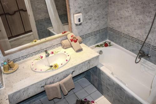 哈马马特Hotel Nesrine Hammamet的浴室配有盥洗盆和浴缸。